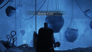 Entering Bonny Gaol in Elden Ring: Shadow of the Erdtree. Huge jars hang from chains and the atmosphere is positively spooky.